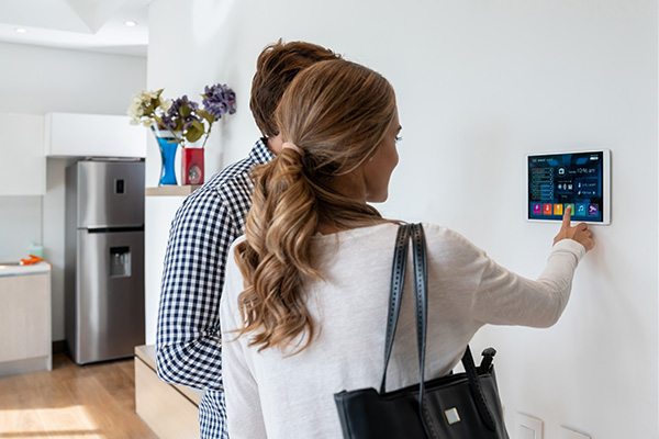 People standing in front of a control panel in their home to show that GORE® Performance Membranes can be used for civil residential and customer application.